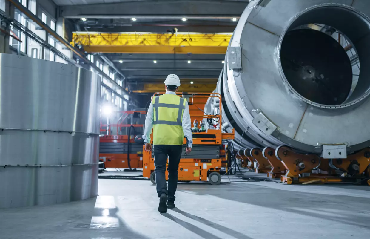 Photo d'un collaborateur technique dans une halle industrielle